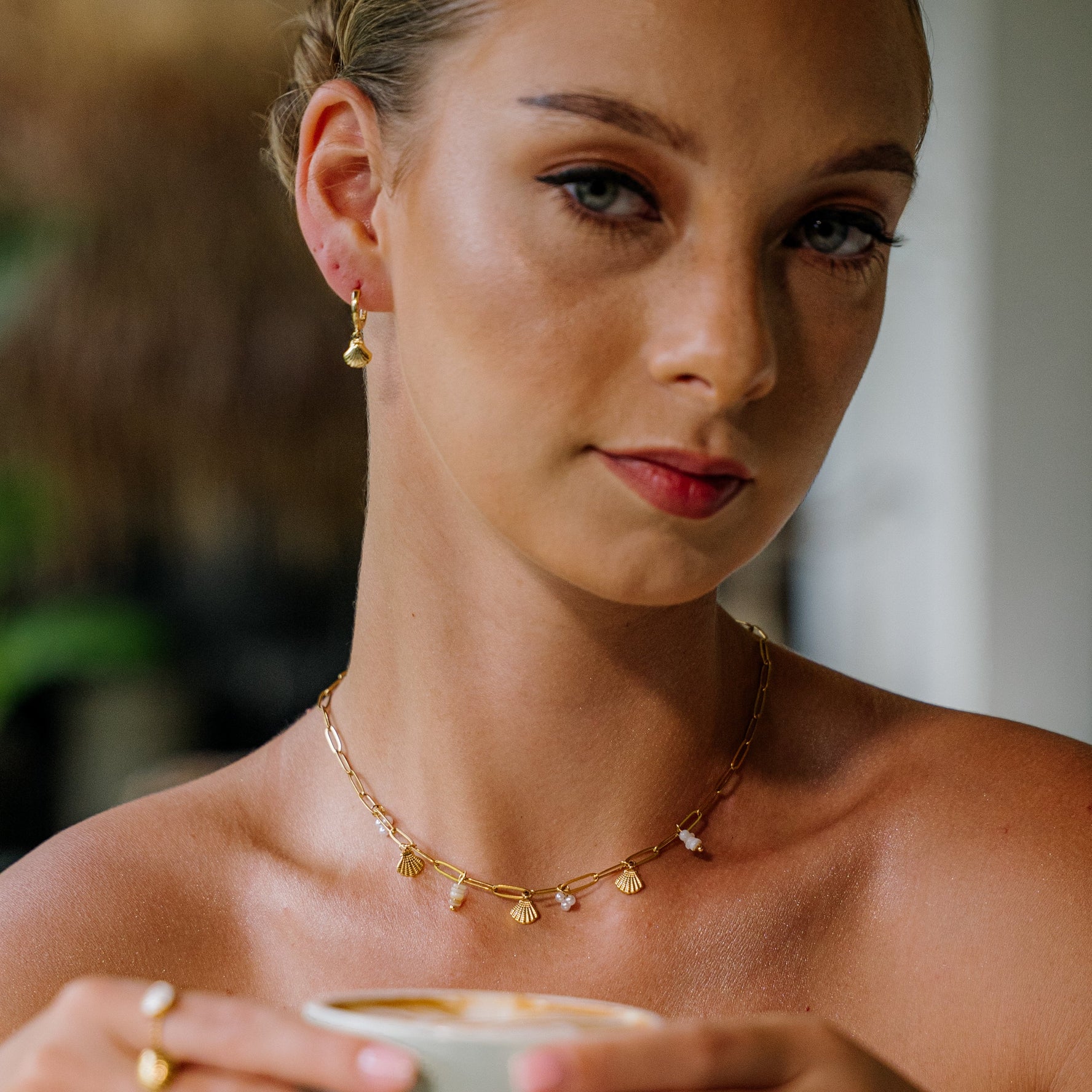 Scallop shell huggie earrings with shell charm pendants.  
