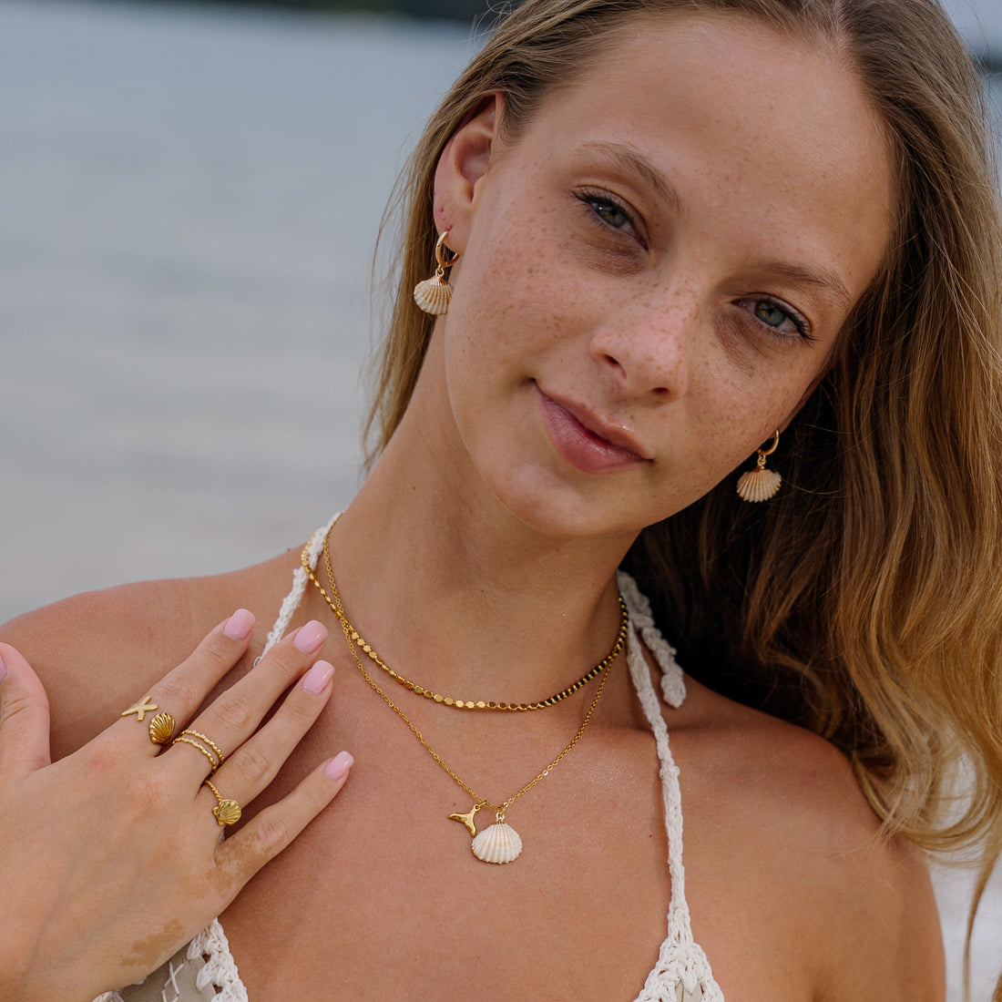 Woman wearing gold  sea shell jewellery 